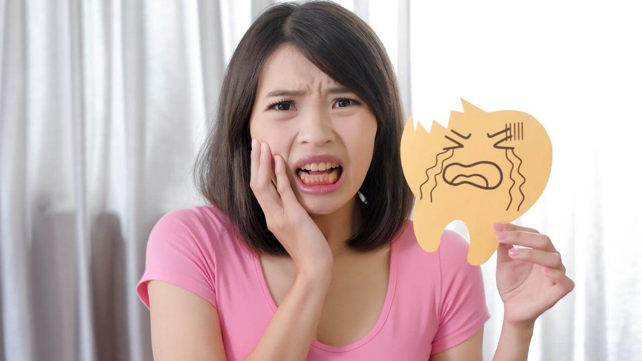 אישה עם שן נמקית לפני טיפול שורש