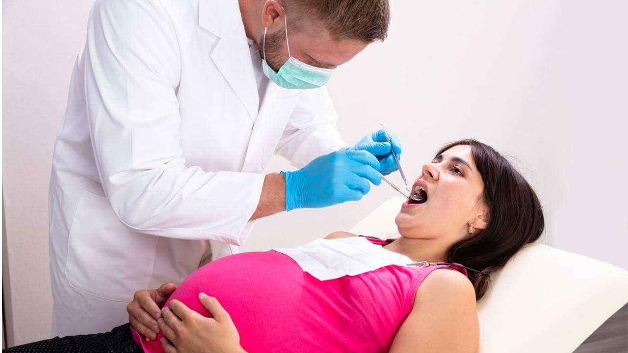 רופא שיניים מבצע טיפול שורש לאישה בהריון